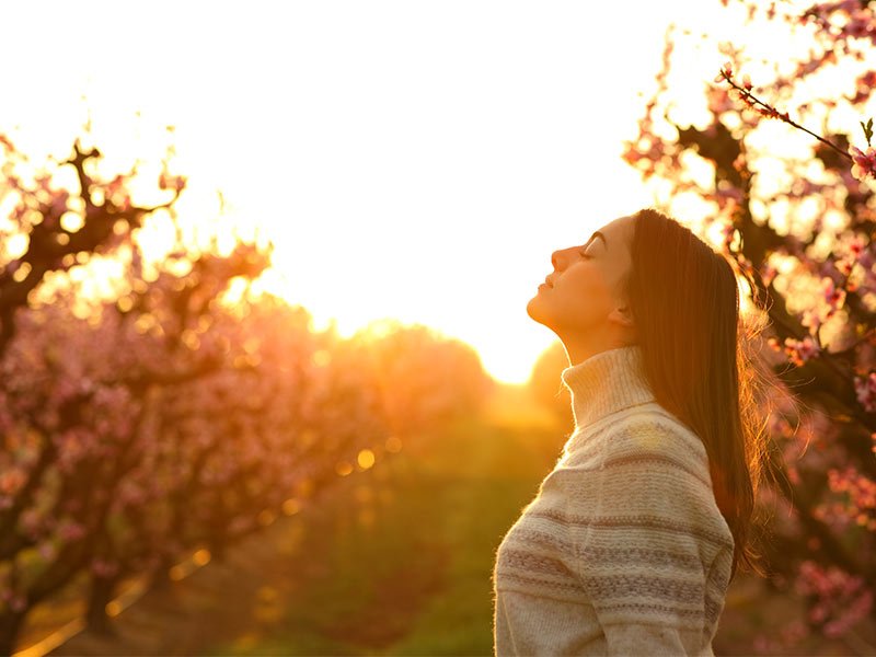 Life Extension, woman with lifted face enjoying the sun and the fresh air in nature